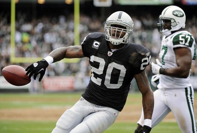 OAKLAND, CA - SEPTEMBER 25: Darren McFadden #20 of the Oakland Raiders tosses the ball away after scoring on a two yard touchdown run against the New York Jets in the first quarter during an NFL football game at the O.co Coliseum September 25, 2011 in Oakland, California.  (Photo by Thearon W. Henderson/Getty Images)