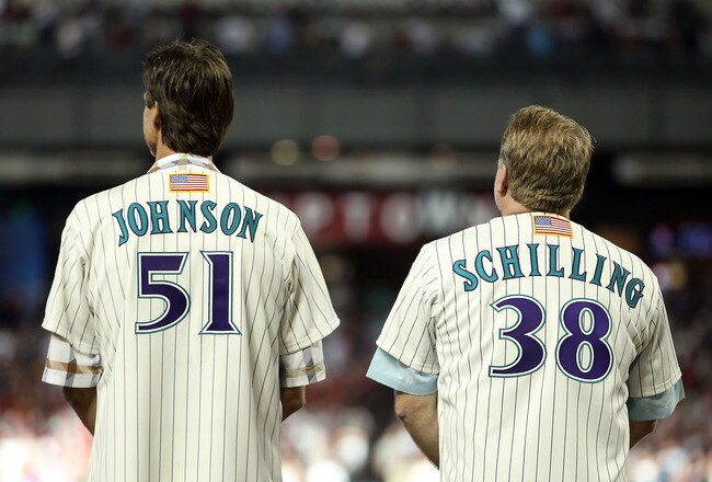 PHOENIX, AZ - SEPTEMBER 10:  Randy Johnson and Curt Schilling, former members of the 2001 Arizona Diamondbacks World Series team stand attended for the National Anthem before the Major League Baseball game against the San Diego Padres at Chase Field on September 10, 2011 in Phoenix, Arizona. The Diamondbacks are celebrating the 10th anniversary of their World Series title.  (Photo by Christian Petersen/Getty Images)
