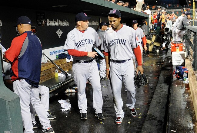 BALTIMORE, MD - SEPTEMBER 28: Carl Crawford #13 of the Boston Red Sox walks in the dugout with first base coach Ron Johnson #50 after a 4-3 loss against the Baltimore Orioles at Oriole Park at Camden Yards on September 28, 2011 in Baltimore, Maryland.  (Photo by Greg Fiume/Getty Images)
