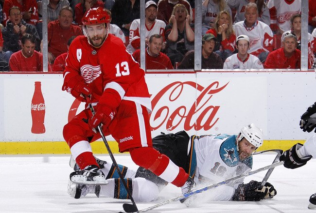 DETROIT - MAY 10: Pavel Datsyuk #13 of the Detroit Red Wings controls the puck in front of Joe Thornton #19 of the San Jose Sharks during the second period in Game Six of the Western Conference Semifinals during the 2011 NHL Stanley Cup Playoffs on May 10, 2011 at Joe Louis Arena in Detroit, Michigan. (Photo by Gregory Shamus/Getty Images)