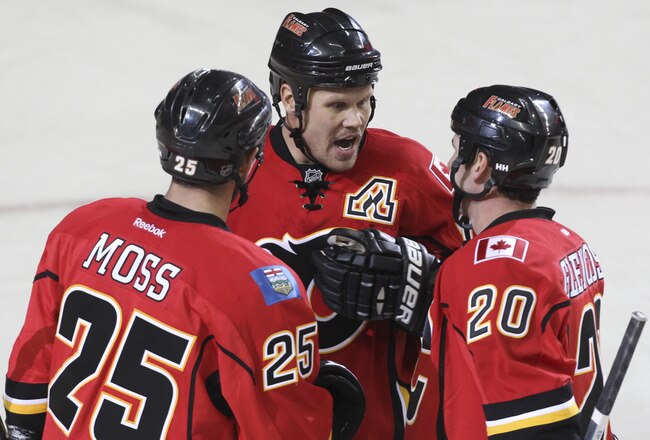 CALGARY, CANADA - SEPTEMBER 29: David Moss #25, Olli Jokinen #13 and Curtis Glencross #20 of the Calgary Flames celebrate a goal against the Phoenix Coyotes in third period NHL preseason action on September 29, 2011 at the Scotiabank Saddledome in Calgary, Alberta, Canada. (Photo by Mike Ridewood/Getty Images)