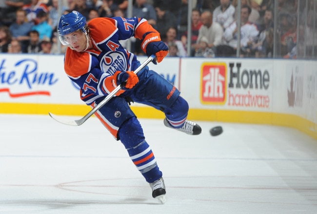 EDMONTON, CANADA - SEPTEMBER 24: Tom Glbert #77 of the Edmonton Oilers dumps the puck into the corner in a game against the Calgary Flames during second period action on September 24, 2011 at the Rexall Place in Edmonton, Alberta, Canada. (Photo by Dale MacMillan/Getty Images)
