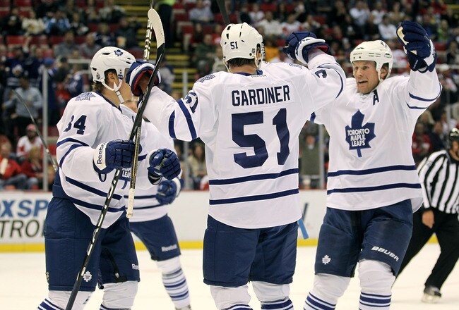 DETROIT, MI - SEPTEMBER 30:  Jake Gardiner #51 of the Toronto Maple Leafs celebrates his first period gaol with teammates while playing the Detroit Red Wings during a pre season game at Joe Louis Arena on September 30, 2011 in Detroit, Michigan.  (Photo by Gregory Shamus/Getty Images)