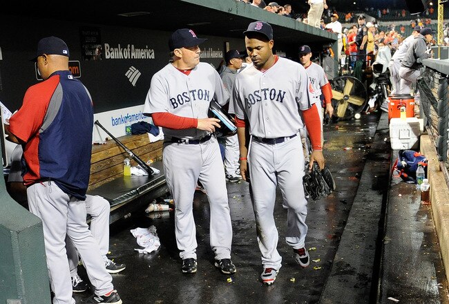 BALTIMORE, MD - SEPTEMBER 28: Carl Crawford #13 of the Boston Red Sox walks in the dugout with first base coach Ron Johnson #50 after a 4-3 loss against the Baltimore Orioles at Oriole Park at Camden Yards on September 28, 2011 in Baltimore, Maryland.  (Photo by Greg Fiume/Getty Images)