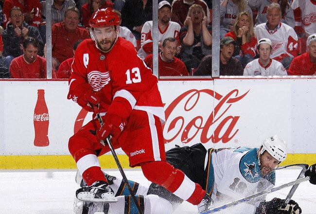 DETROIT - MAY 10: Pavel Datsyuk #13 of the Detroit Red Wings controls the puck in front of Joe Thornton #19 of the San Jose Sharks during the second period in Game Six of the Western Conference Semifinals during the 2011 NHL Stanley Cup Playoffs on May 10, 2011 at Joe Louis Arena in Detroit, Michigan. (Photo by Gregory Shamus/Getty Images)