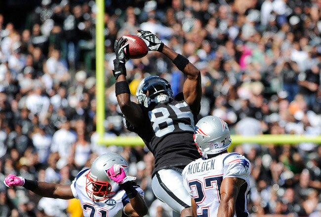 OAKLAND, CA - OCTOBER 02: Darrius Heyward-Bey #85 of the Oakland Raiders catches this pass over Sergio Brown #31 and Antwaun Molden #27 of the New England Patriots during an NFL football game at O.co Coliseum on October 2, 2011 in Oakland, California.  (Photo by Thearon W. Henderson/Getty Images)