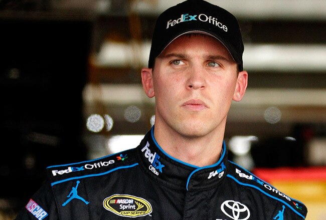DOVER, DE - SEPTEMBER 30: Denny Hamlin, driver of the #11 FedEx Office Toyota, stands in the garage
 during practice for the NASCAR Sprint Cup Series AAA 400 at Dover International Speedway on September 30, 2011 in Dover, Delaware.  (Photo by Geoff Burke/Getty Images)