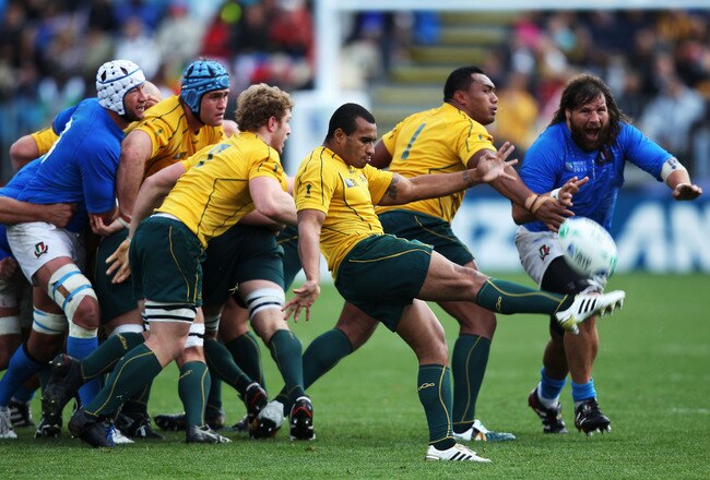 AUCKLAND, NEW ZEALAND - SEPTEMBER 11:  Will Genia of the Wallabies (C) kicks the ball clear under pressure during the IRB 2011 Rugby World Cup Pool C match between Australia and Italy at North Harbour Stadium on September 11, 2011 in Auckland, New Zealand.  (Photo by Warren Little/Getty Images)