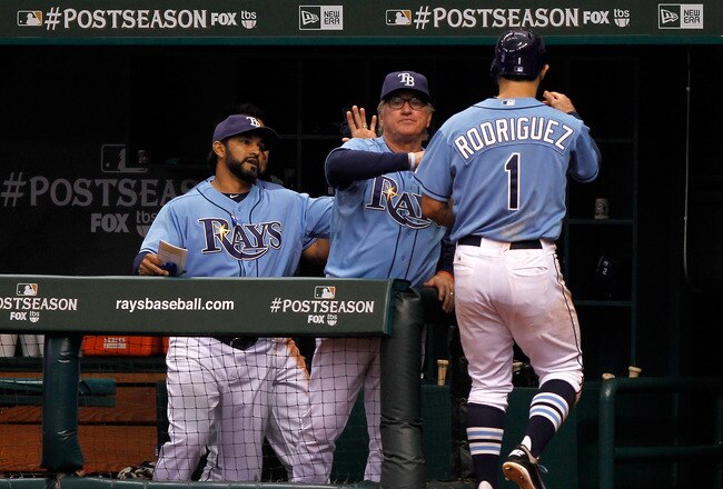 ST PETERSBURG, FL - OCTOBER 04:  Sean Rodriguez #1 of the Tampa Bay Rays is greeted at the dugout by manager Joe Maddon after scoring in the ninth inning against the Texas Rangers in Game Four of the American League Division Series at Tropicana Field on October 4, 2011 in St Petersburg, Florida.  (Photo by Mike Ehrmann/Getty Images)