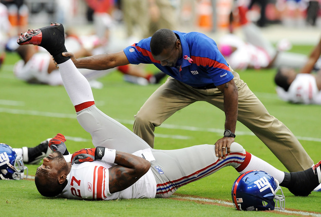 GLENDALE, AZ - OCTOBER 02:  Brandon Jacobs #27 of the New York Giants gets some help stretching prior to the game against the Arizona Cardinals at University of Phoenix Stadium on October 2, 2011 in Glendale, Arizona.  (Photo by Norm Hall/Getty Images)