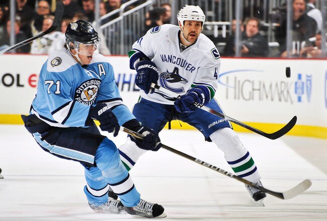 PITTSBURGH - NOVEMBER 17:  Andrew Alberts #41 of the Vancouver Canucks flips the puck past Evgeni Malkin #71 of the Pittsburgh Penguins on November 17, 2010 at Consol Energy Center in Pittsburgh, Pennsylvania.  (Photo by Jamie Sabau/Getty Images)