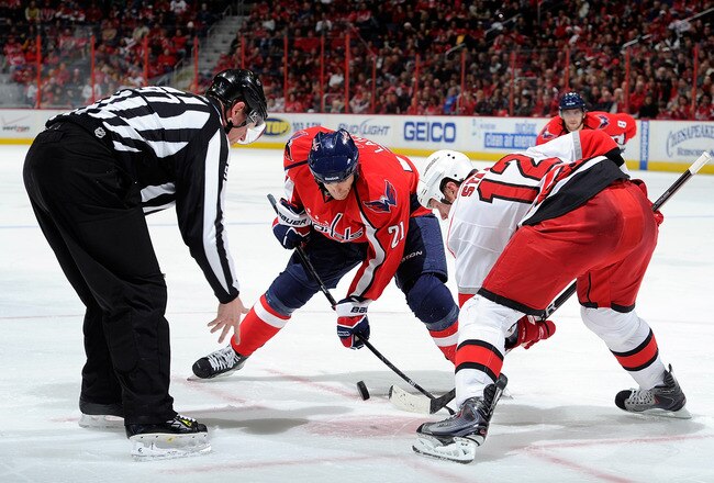 WASHINGTON - NOVEMBER 28:  Brooks Laich #21 of the Washington Capitals takes a face off against Eric Staal #12 of the Carolina Hurricanes at the Verizon Center on November 28, 2010 in Washington, DC.  (Photo by Greg Fiume/Getty Images)