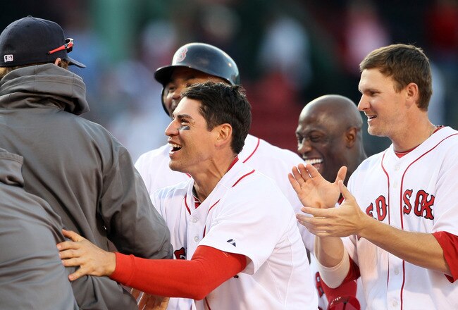 BOSTON, MA - JUNE 04:  Jacoby Ellsbury #2, Drew Sutton #44 and Carl Crawford #13 and the rest of the Boston Red Sox surround J.D. Drew after he hit the game winning hit in the bottom of the 14th inning against the Oakland Athletics on June 4, 2011 at Fenway Park in Boston, Massachusetts. The Boston Red Sox defeated the Oakland Athletics 9-8 in 14 innings.  (Photo by Elsa/Getty Images)