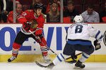 CHICAGO, IL - OCTOBER 13: Daniel Carcillo #13 of the Chicago Blackhawks controls the puck as Alexander Burmistrov #8 of the Winnipeg Jets closes in at the United Center on October 13, 2011 in Chicago, Illinois.  (Photo by Jonathan Daniel/Getty Images)