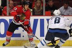 CHICAGO, IL - OCTOBER 13: Daniel Carcillo #13 of the Chicago Blackhawks controls the puck as Alexander Burmistrov #8 of the Winnipeg Jets closes in at the United Center on October 13, 2011 in Chicago, Illinois.  (Photo by Jonathan Daniel/Getty Images)