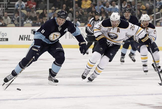 PITTSBURGH, PA - OCTOBER 15: Jordan Staal #11 of the Pittsburgh Penguins carries the puck past Thomas Vanek #26 of the Buffalo Sabres during the game on October 15, 2011 at CONSOL Energy Center in Pittsburgh, Pennsylvania.  (Photo by Jared Wickerham/Getty Images)