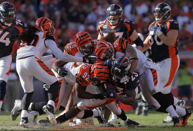 DENVER, CO - SEPTEMBER 18:  Running back Willis McGahee #23 of the Denver Broncos is tackled by Frostee Rucker #92, Rey Maualuga #58 and Manny Lawson #99 of the Cincinnati Bengals rushes against the Cincinnati Bengals at Sports Authority Field at Mile High on September 18, 2011 in Denver, Colorado. The Broncos defeated the Bengals 24-22.  (Photo by Doug Pensinger/Getty Images)