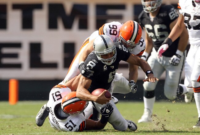 OAKLAND, CA - OCTOBER 16:  Jason Campbell #8 of the Oakland Raiders is hit by Chris Gocong #51 and Scott Fujita #99 of the Cleveland Browns at O.co Coliseum on October 16, 2011 in Oakland, California. Campbell was injured on the play and had to be helped from the field.   (Photo by Ezra Shaw/Getty Images)