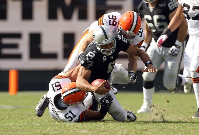 OAKLAND, CA - OCTOBER 16:  Jason Campbell #8 of the Oakland Raiders is hit by Chris Gocong #51 and Scott Fujita #99 of the Cleveland Browns at O.co Coliseum on October 16, 2011 in Oakland, California. Campbell was injured on the play and had to be helped from the field.   (Photo by Ezra Shaw/Getty Images)