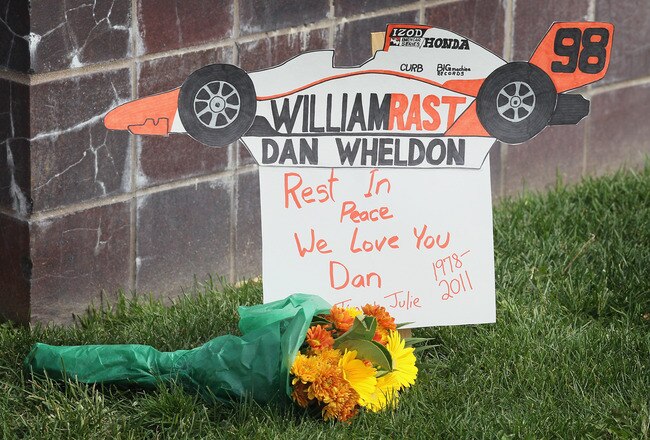 INDIANAPOLIS, IN - OCTOBER 17:  Flower lay by the gate at the Indianapolis Motor Speedway along with other tributes left by fans to two-time Indianapolis 500 winner Dan Wheldon on October 17, 2011 in Indianapolis, Indiana. Wheldon, winner of the 2011 Indy 500, was killed in a crash yesterday at the Izod IndyCar series season finale at Las Vegas Motor Speedway.  (Photo by Scott Olson/Getty Images)