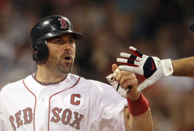BOSTON, MA - AUGUST 31:  Jason Varitek #33 of the Boston Red Sox is congratulated by Adrian Gonzalez #28 after Varitek scored in the sixth inning against the New York Yankees on August 31, 2011 at Fenway Park in Boston, Massachusetts.  (Photo by Elsa/Getty Images)
