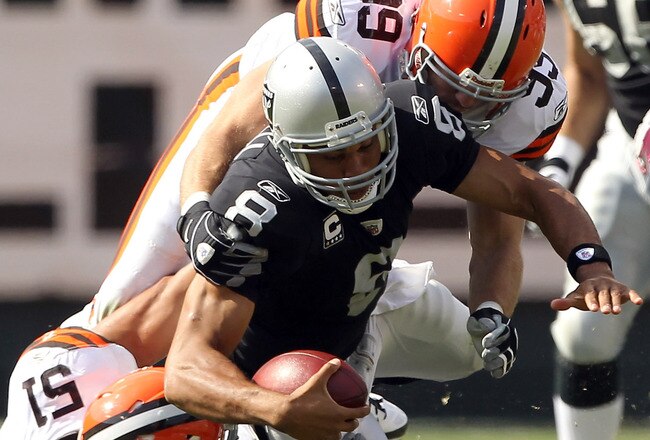 OAKLAND, CA - OCTOBER 16:  Jason Campbell #8 of the Oakland Raiders is hit by Chris Gocong #51 and Scott Fujita #99 of the Cleveland Browns at O.co Coliseum on October 16, 2011 in Oakland, California. Campbell was injured on the play and had to be helped from the field.   (Photo by Ezra Shaw/Getty Images)