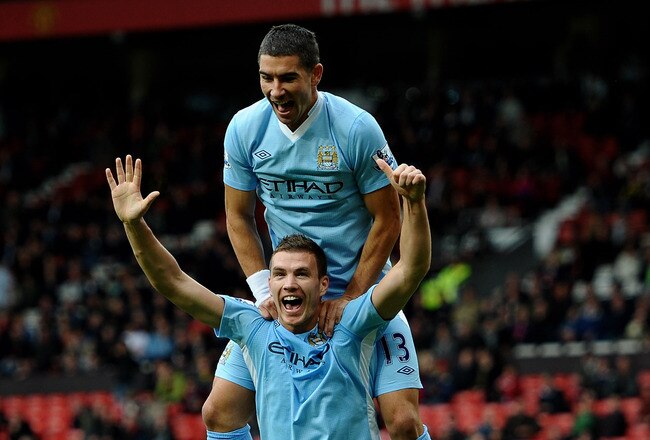 MANCHESTER, ENGLAND - OCTOBER 23:  Edin Dzeko of Manchester City celebrates scoring his team's sixth goal with team mate Aleksandar Kolarov  during the Barclays Premier League match between Manchester United and Manchester City at Old Trafford on October 23, 2011 in Manchester, England.  (Photo by Laurence Griffiths/Getty Images)