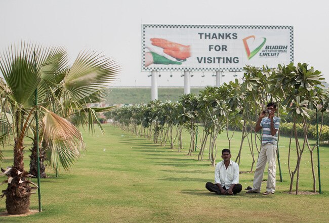 GREATER NOIDA, INDIA - OCTOBER 18:  Men sit on a grass lawn during the media preview of the Buddh International Circuit on October 18, 2011 in Greater Noida, India. India's first F1 race is scheduled to take place on October 30, 2011.  (Photo by Daniel Berehulak/Getty Images)