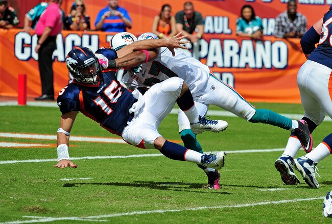 MIAMI GARDENS, FL - OCTOBER 23: Tim Tebow #15 of the Denver Broncos is pressured by Yeremiah Bell #37 of the Miami Dolphins at Sun Life Stadium on October 23, 2011 in Miami Gardens, Florida. (Photo by Scott Cunningham/Getty Images)