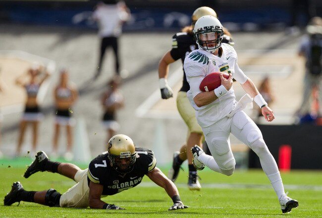 BOULDER, CO - OCTOBER 22:  Quarterback Bryan Bennett #2 of the Oregon Ducks runs for a first down past a diving attempt by defensive back Anthony Perkins #7 of the Colorado Buffaloes during the first quarter at Folsom Field on October 22, 2011 in Boulder, Colorado. (Photo by Justin Edmonds/Getty Images)