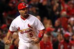 ST LOUIS, MO - OCTOBER 27:  Albert Pujols #5 of the St. Louis Cardinals celebrates after scoring on a game-tying two-run triple by David Freese #23 in the ninth inning during Game Six of the MLB World Series against the Texas Rangers at Busch Stadium on October 27, 2011 in St Louis, Missouri. The Cardinals won 10-9 in 11 innings.  (Photo by Jamie Squire/Getty Images)