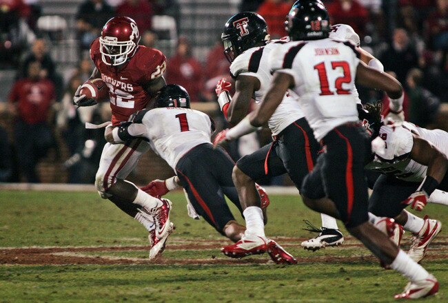 NORMAN, OK - OCTOBER 22:  Running back Roy Finch #22 of the Oklahoma Sooners is tackled by safety Terrence Bullitt #1during the second half October 22, 2011 at Gaylord Family-Oklahoma Memorial Stadium in Norman, Oklahoma. Texas Tech upset Oklahoma 41-38. (Photo by Brett Deering/Getty Images)