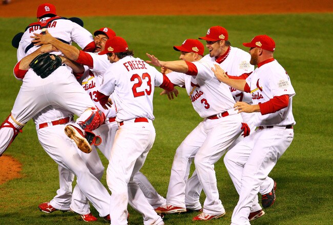 ST LOUIS, MO - OCTOBER 28:  Yadier Molina #4, Gerald Laird #13 and David Freese #23 of the St. Louis Cardinals celebrate after defeating the Texas Rangers 6-2 to win the World Series in Game Seven of the MLB World Series at Busch Stadium on October 28, 2011 in St Louis, Missouri.  (Photo by Dilip Vishwanat/Getty Images)