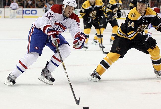 BOSTON, MA - OCTOBER 27:  Travis Moen #32 of the Montreal Canadiens heads for the net as Joe Corvo #14 of the Boston Bruins defends on October 27, 2011 at TD Garden in Boston, Massachusetts.  (Photo by Elsa/Getty Images)