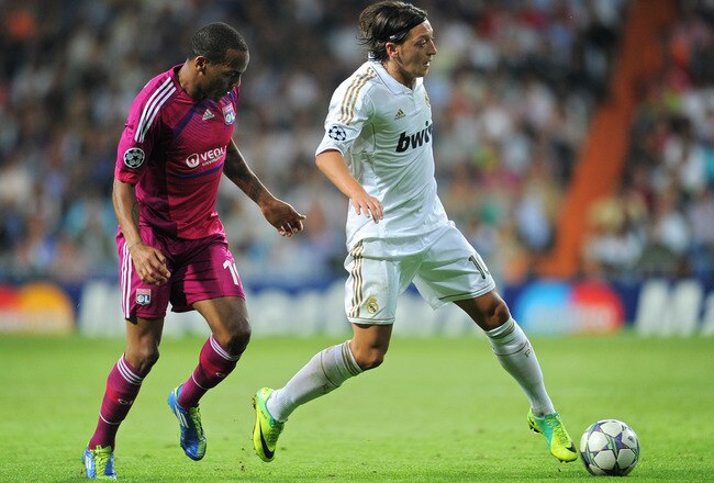 MADRID, SPAIN - OCTOBER 18:  Mesut Ozil (R) of Real Madrid shields Jimmy Briand of Olympique Lyonnais from the ball during the UEFA Champions League group D match between Real Madrid and Olympique Lyonnais at the Estadio Santiago Bernabeu on October 18, 2011 in Madrid, Spain.  (Photo by Jasper Juinen/Getty Images)