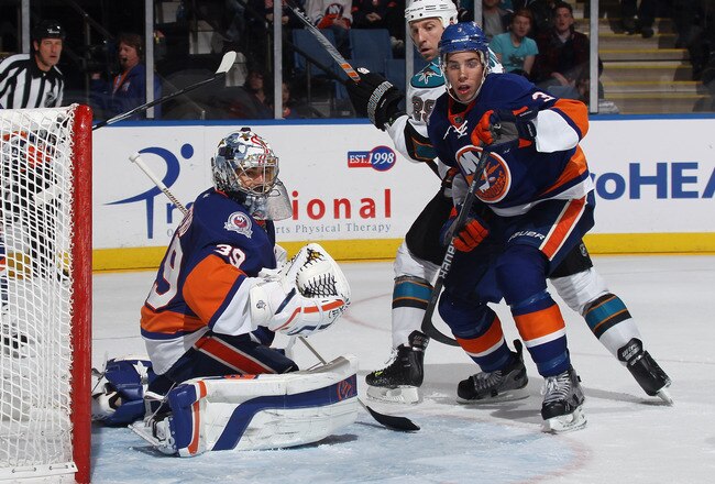 UNIONDALE, NY - OCTOBER 29: Rick DiPietro #39 and Travis Hamonic #3 of the New York Islanders defend against Ryane Clowe #29 of the San Jose Sharks at the Nassau Veterans Memorial Coliseum on October 29, 2011 in Uniondale, New York. The Sharks defeated the Islanders 3-2 in overtime. (Photo by Bruce Bennett/Getty Images)