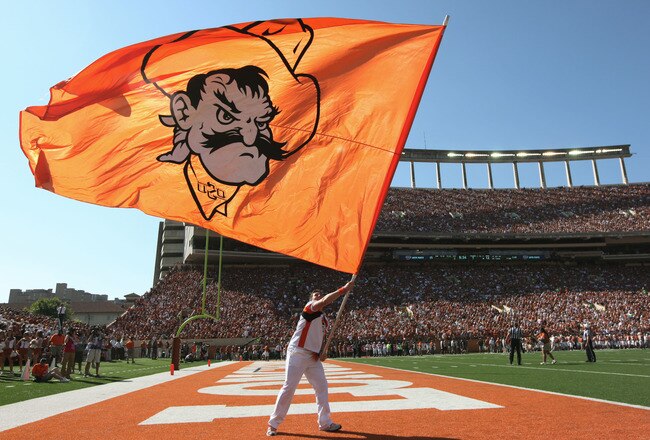 AUSTIN, TX - OCTOBER 15:  An Oklahoma State cheerleader flies the Cowboys' flag after a touchdown against the Texas Longhorns on October 15, 2011 at Darrell K. Royal-Texas Memorial Stadium in Austin, Texas.  Oklahoma State beat Texas 38-26.  (Photo by Erich Schlegel/Getty Images)