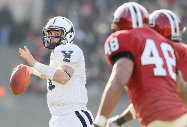CAMBRIDGE, MA - NOVEMBER 20:  Patrick Witt #11 of the Yale Bulldogs looks to pass as Josue Ortiz of the Harvard Crimson defends on November 20, 2010 at Harvard Stadium in Cambridge, Massachusetts.  Harvard defeated Yale 28-21.  (Photo by Elsa/Getty Images)