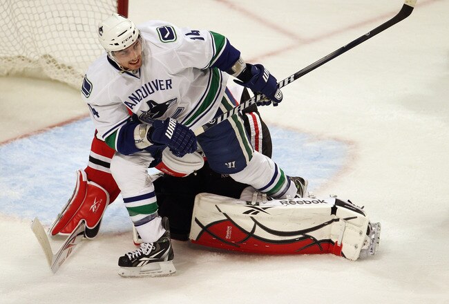 CHICAGO, IL - APRIL 19: Alexandre Burrows #14 of the Vancouver Canucks trips over Corey Crawford #50 of the Chicago Blackhawks in Game Four of the Western Conference Quarterfinals during the 2011 NHL Stanley Cup Playoffs at the United Center on April 19, 2011 in Chicago, Illinois. The Blackhawks defeated the Canucks 7-2. (Photo by Jonathan Daniel/Getty Images)