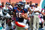 MIAMI GARDENS, FL - OCTOBER 23: Tim Tebow #15 of the Denver Broncos carries the ball against Cameron Wake #91 of the Miami Dolphins at Sun Life Stadium on October 23, 2011 in Miami Gardens, Florida. (Photo by Scott Cunningham/Getty Images)