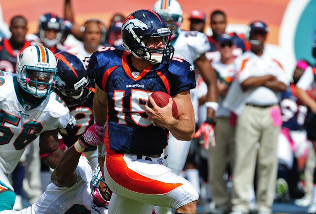 MIAMI GARDENS, FL - OCTOBER 23: Tim Tebow #15 of the Denver Broncos carries the ball against Cameron Wake #91 of the Miami Dolphins at Sun Life Stadium on October 23, 2011 in Miami Gardens, Florida. (Photo by Scott Cunningham/Getty Images)