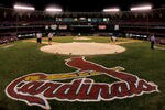ST. LOUIS - OCTOBER 19:  Stadium workers cover home plate with a tarp as security keeps a close eye on fans remaining in the stands following the St. Louis Cardinals 5-1 loss the Houston Astros during Game Six of the National League Championship Series October 19, 2005 at Busch Stadium in St. Louis, Missouri. With the win the Astros won the series 4-2 and advanced to the World Series. The game was the last to be played in the 40 year history of Busch Stadium. A new Busch Stadium (under construction) will be the new home of the Cardinals starting with the opening of the 2006 MLB regular season. (Photo by Brian Bahr/Getty Images)