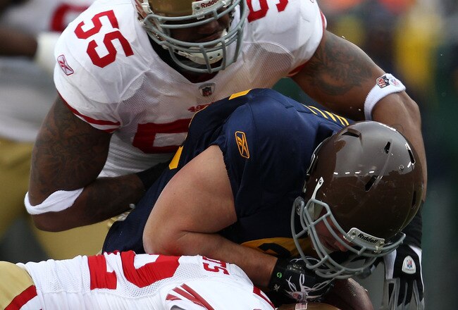 GREEN BAY, WI - DECEMBER 05: Ahmad Brooks #55 and Nate Clements #22 of the San Francisco 49ers tackle John Kuhn #30 of the Green Bay Packers at Lambeau Field on December 5, 2010 in Green Bay, Wisconsin. The Packers defeated the 49ers 34-16.  (Photo by Jonathan Daniel/Getty Images)