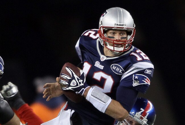 FOXBORO, MA - NOVEMBER 06:   Tom Brady #12 of the New England Patriots scrambles as  Dave Tollefson #71 of the New York Giants defends on November 6, 2011 at Gillette Stadium in Foxboro, Massachusetts.  (Photo by Elsa/Getty Images)