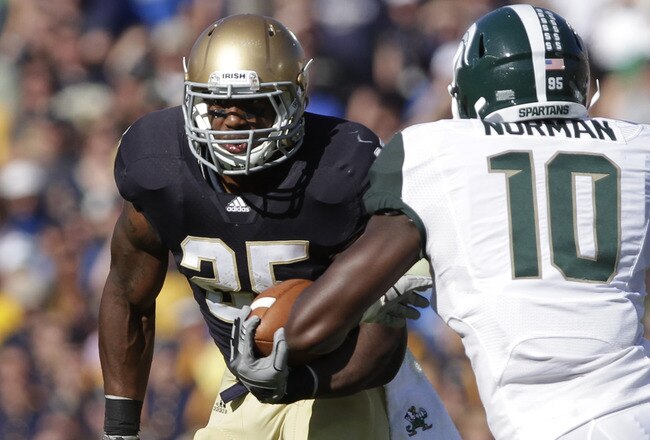 SOUTH BEND, IN - SEPTEMBER 17:  Jonas Gray #25 of the Notre Dame Fighting Irish rushes on Andrew Maxwell  #10  the Michigan State Spartans during the first half September 17, 2011at Notre Dame Stadium in South Bend, Indiana. Notre Dame defeated Michigan State 31-13. (Photo by John Gress/Getty Images)