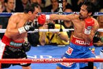 LAS VEGAS, NV - NOVEMBER 12:  Manny Pacquiao (R) throws a right at Juan Manuel Marquez during the seventh round of their WBO world welterweight title fight at the MGM Grand Garden Arena November 12, 2011 in Las Vegas, Nevada. Pacquiao retained his title with a majority decision victory.  (Photo by Ethan Miller/Getty Images)
