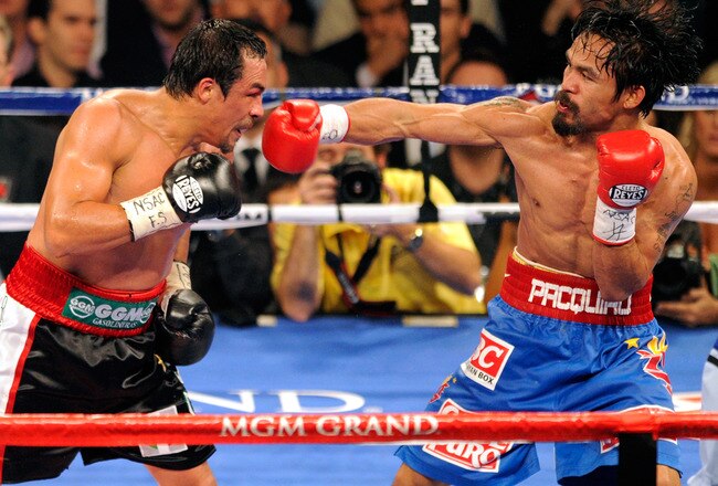 LAS VEGAS, NV - NOVEMBER 12:  Manny Pacquiao (R) throws a right at Juan Manuel Marquez during the seventh round of their WBO world welterweight title fight at the MGM Grand Garden Arena November 12, 2011 in Las Vegas, Nevada. Pacquiao retained his title with a majority decision victory.  (Photo by Ethan Miller/Getty Images)