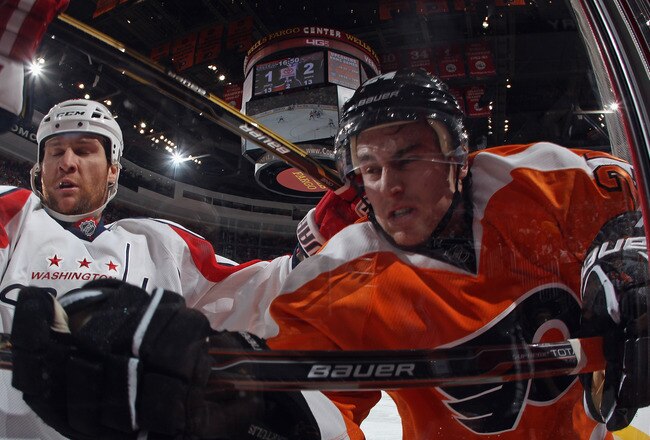 PHILADELPHIA, PA - OCTOBER 20: Dennis Wideman #6 of the Washington Capitals checks Matt Read #24 of the Philadelphia Flyers into the glass during the second period at the Wells Fargo Center on October 20, 2011 in Philadelphia, Pennsylvania.  (Photo by Bruce Bennett/Getty Images)