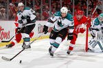 DETROIT, MI - OCTOBER 28: Andrew Desjardins #69 of the San Jose Sharks tries to control the puck in front of Justin Abdelkader #8 of the Detroit Red Wings at Joe Louis Arena on October 28, 2011 in Detroit, Michigan. San Jose won the game 4-2. (Photo by Gregory Shamus/Getty Images)