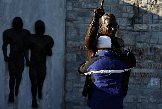 STATE COLLEGE, PA - NOVEMBER 12:  A fan pays respect to a statue of former Penn State football coach Joe Paterno before the Penn State against Nebraska football game at Beaver Stadium on November 12, 2011 in State College, Pennsylvania. Head football coach Joe Paterno was fired amid allegations that former Penn State defensive coordinator Jerry Sandusky was involved with child sex abuse. Penn State is playing their final home football game against Nebraska.  (Photo by Patrick Smith/Getty Images)